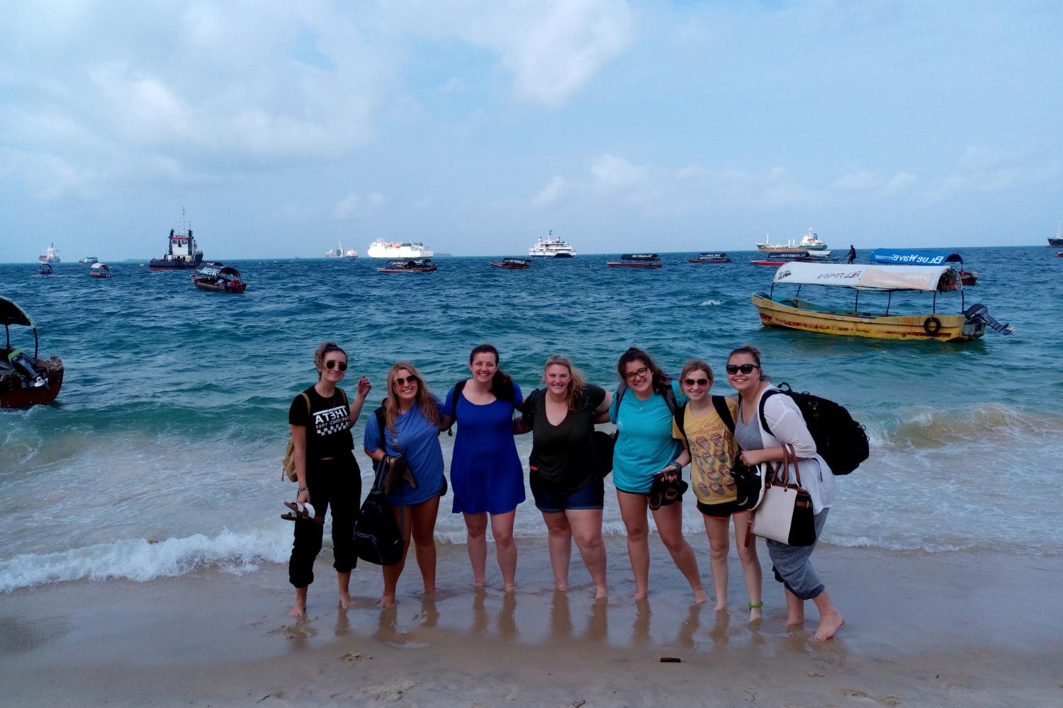 Students pose for a photo seaside on a J-Term study tour in Tanzania.